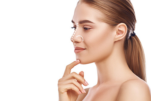 A beautiful woman touching her chin, dotted lines on her nose to indicate a potential rhinoplasty procedure from The Facial Center in Charleston, WV