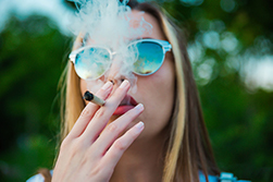 White woman blowing smoke from a cigarette