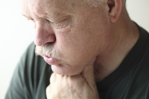 Man holding throat before appointment at The Facial Center in Charleston, WV